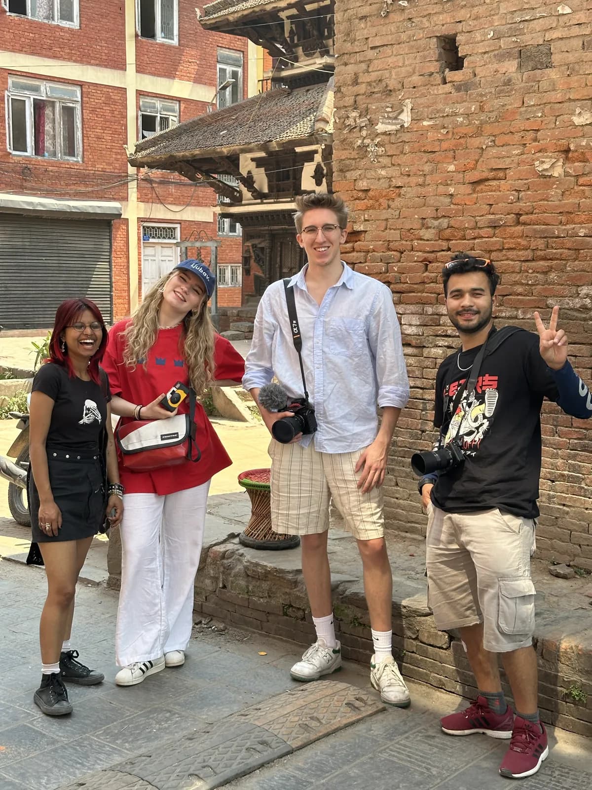 The crew on location in a Kathmandu street, cameras in hand, with a brick temple behind them